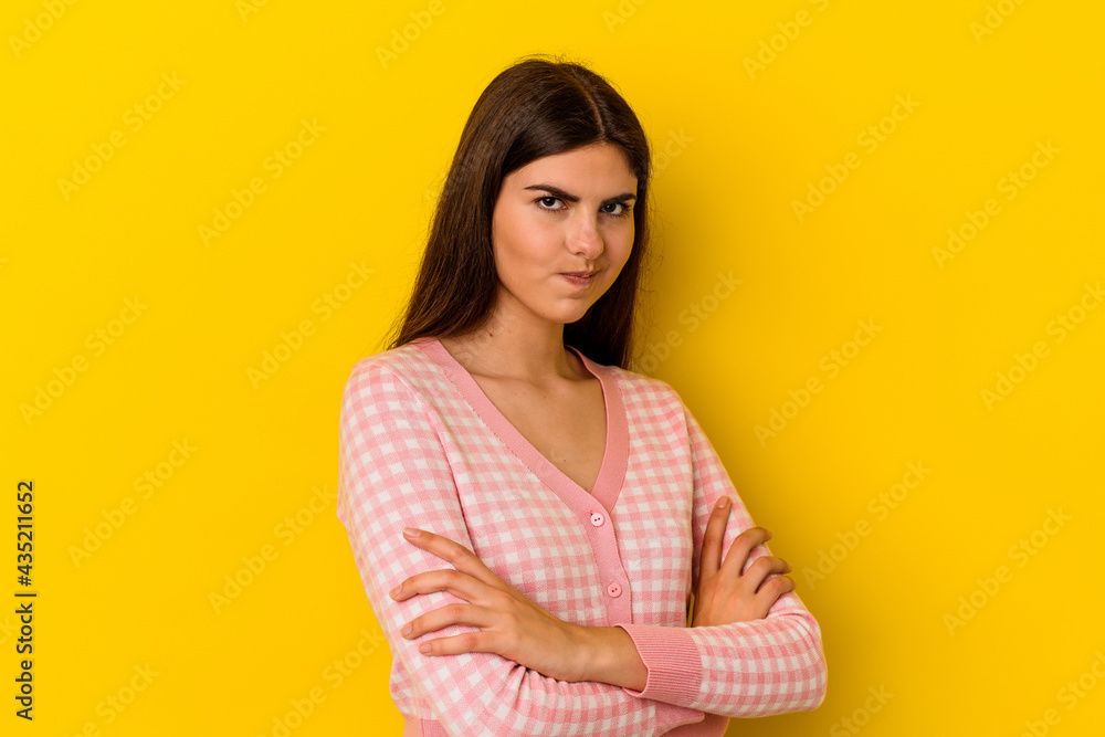 Obraz premium Young caucasian woman isolated on yellow background frowning face in displeasure, keeps arms folded.