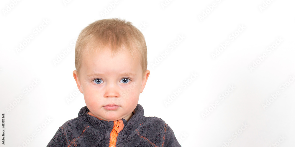 ortrait of little caucasian sad boy. Baby face with with bad emotions isolated on white background. Panorama banner.