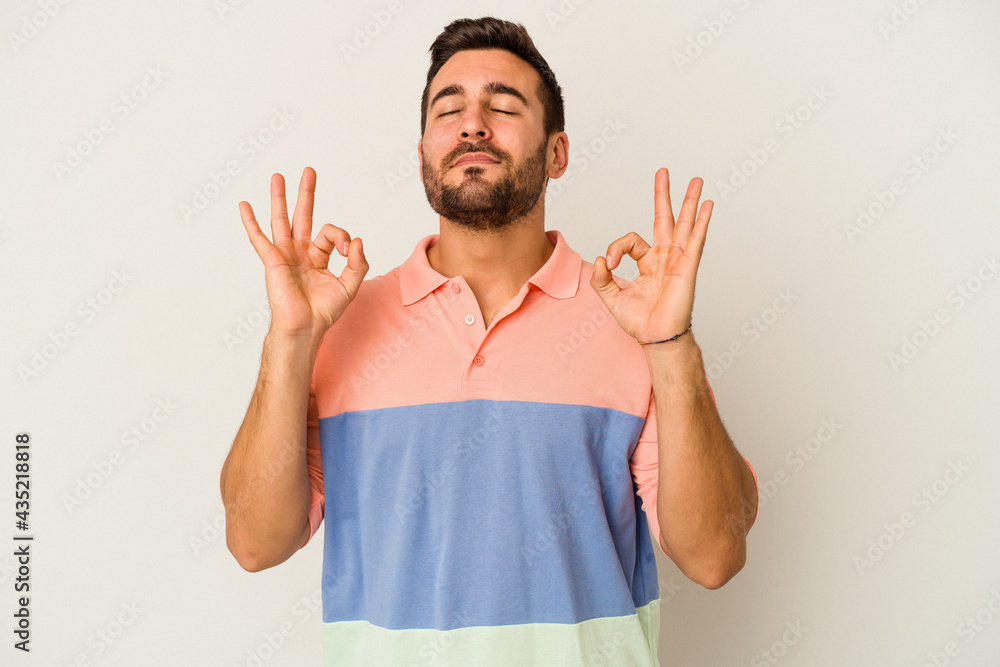 Young caucasian man isolated on white background relaxes after hard working day, she is performing yoga. Young caucasian man isolated on white background relaxes after hard working day, she is performing yoga.