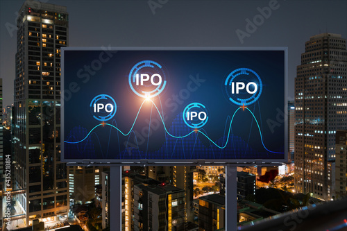 IPO icon hologram on road billboard over night panorama city view of Bangkok. The hub of initial public offering in Southeast Asia. The concept of exceeding business opportunities.