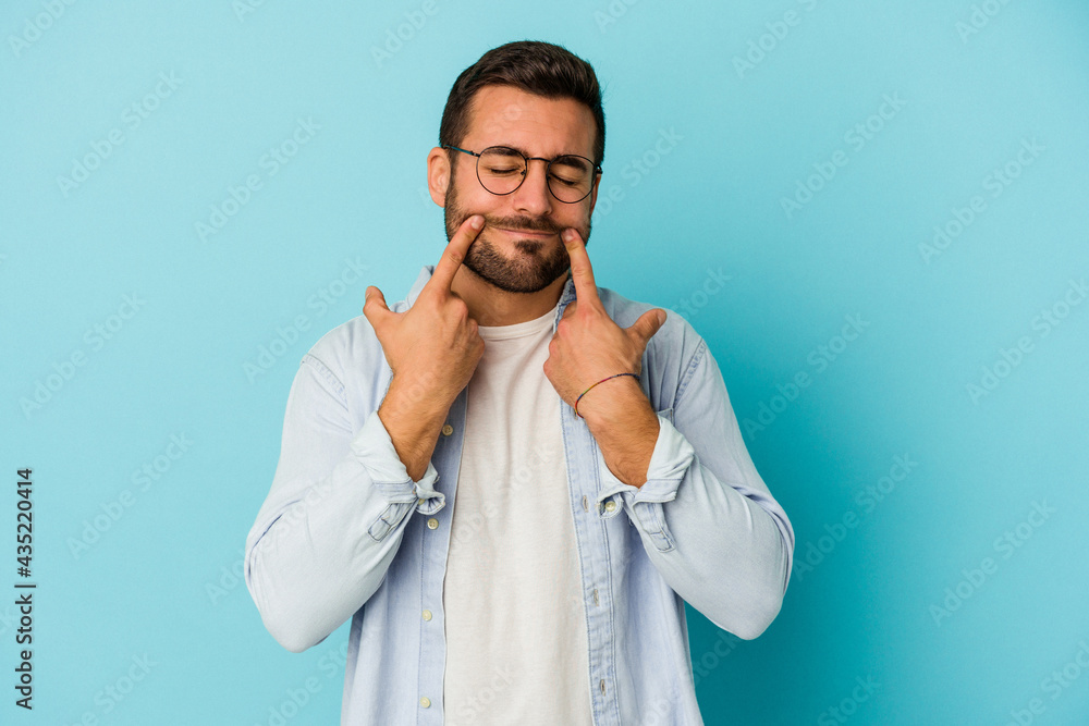 Young caucasian man isolated on blue background doubting between two options. Young caucasian man isolated on blue background doubting between two options.