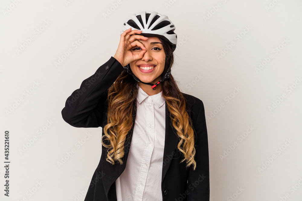 Young mexican woman riding a bicycle to work isolated on white background excited keeping ok gesture on eye. Young mexican woman riding a bicycle to work isolated on white background excited keeping ok gesture on eye.