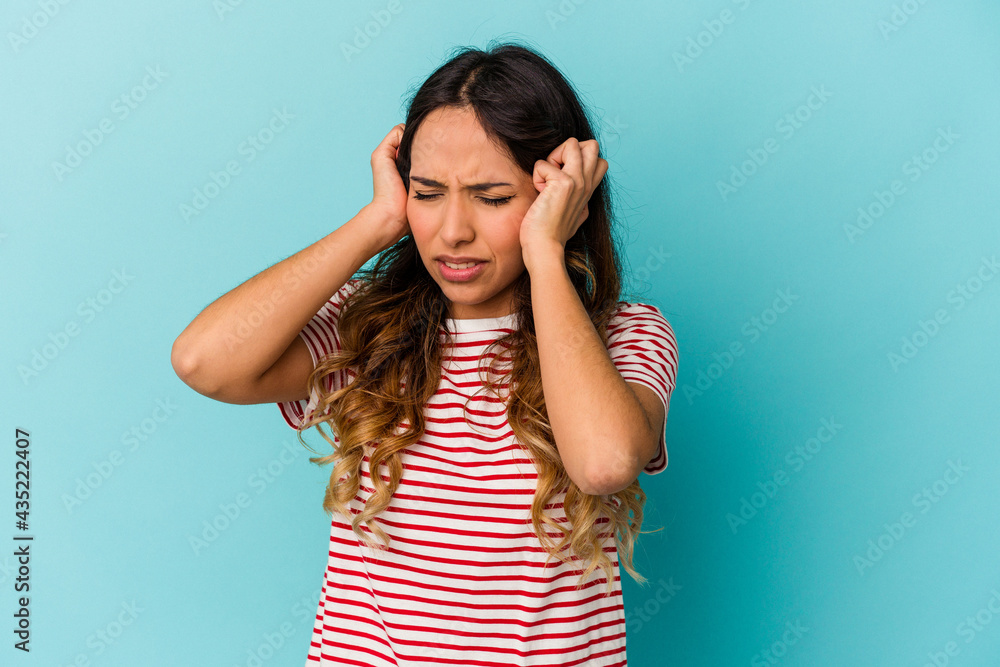 Young mexican woman isolated on blue background covering ears with hands. Young mexican woman isolated on blue background covering ears with hands.
