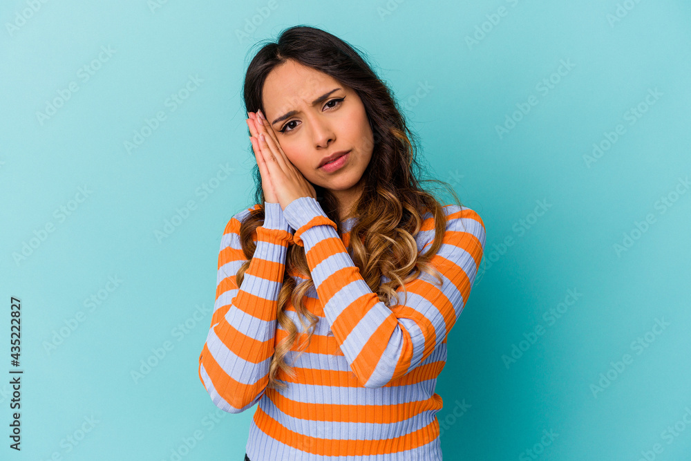 Young mexican woman isolated on blue background yawning showing a tired gesture covering mouth with hand. Young mexican woman isolated on blue background yawning showing a tired gesture covering mouth with hand.