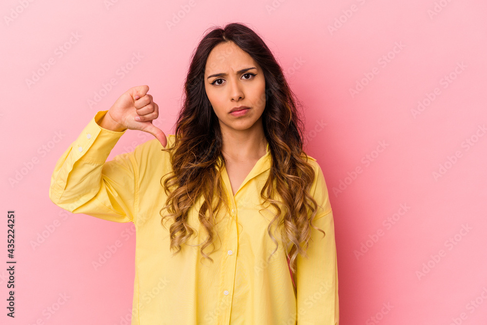 Young mexican woman isolated on pink background showing a dislike gesture, thumbs down. Disagreement concept. Young mexican woman isolated on pink background showing a dislike gesture, thumbs down. Disagreement concept.