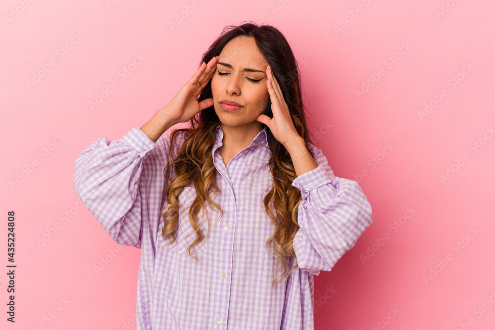 Young mexican woman isolated on pink background touching temples and having headache. Young mexican woman isolated on pink background touching temples and having headache.
