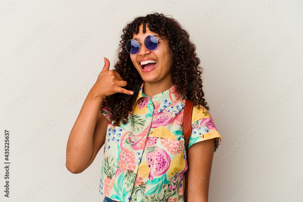 Young mixed race woman wearing sunglasses taking a vacation isolated showing a mobile phone call gesture with fingers. Young mixed race woman wearing sunglasses taking a vacation isolated showing a mobile phone call gesture with fingers.