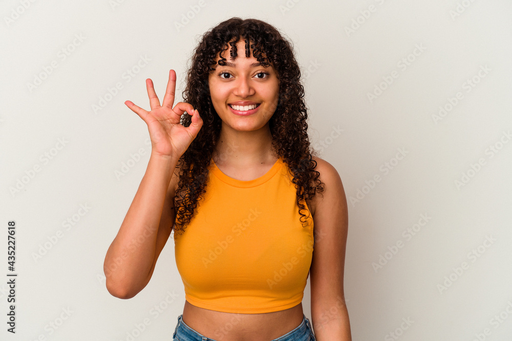 Young mixed race woman isolated on white background cheerful and confident showing ok gesture. Young mixed race woman isolated on white background cheerful and confident showing ok gesture.
