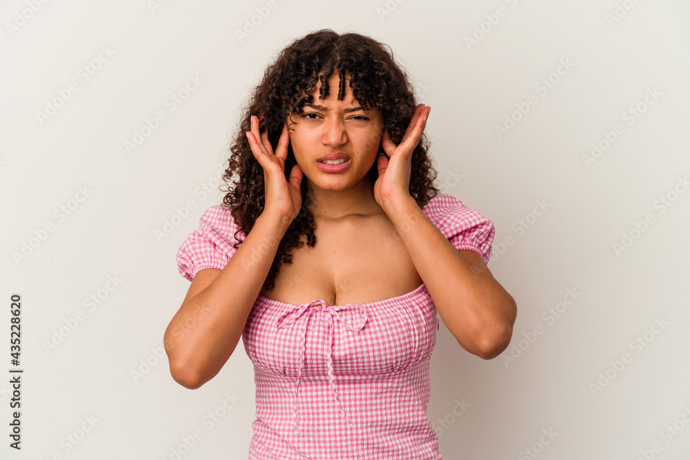 Young mixed race woman isolated on white background covering ears with fingers, stressed and desperate by a loudly ambient. Young mixed race woman isolated on white background covering ears with fingers, stressed and desperate by a loudly ambient.