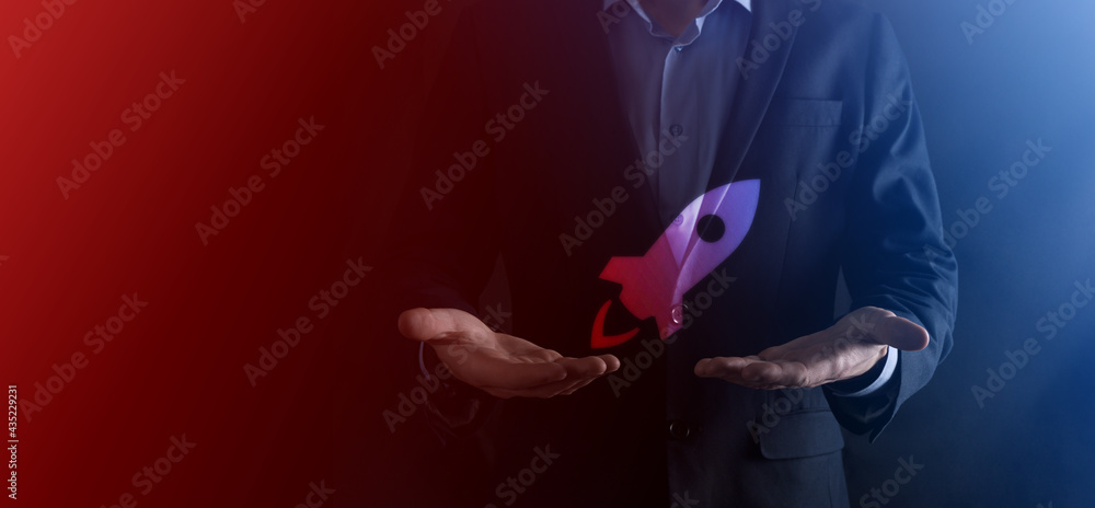 Startup business concept, Businessman holding tablet and icon rocket is launching and soar flying out from screen with network connection on dark background. Startup business concept, Businessman holding tablet and icon rocket is launching and soar flying out from screen with network connection on dark background.