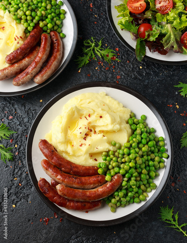 Canvas Print Pork Chipolata sausages with home cooked mashed potato and green peas