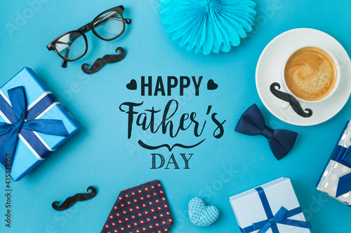 Happy Fathers day concept with coffee cup,  tie bow and gift box on blue background photo