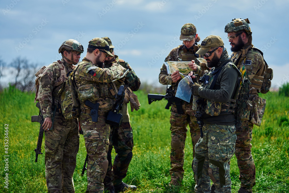 A group of military soldiers are examining the map A group of military soldiers are examining the map