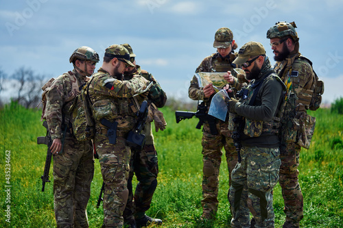A group of military soldiers are examining the map