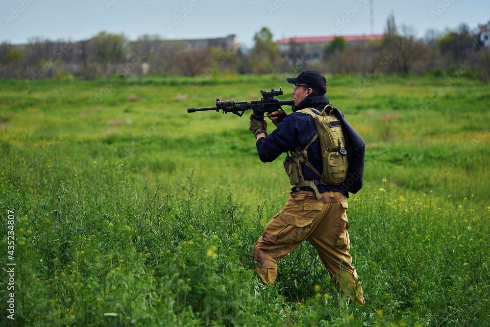 Airsoft player in military uniform aims at the enemy Airsoft player in military uniform aims at the enemy