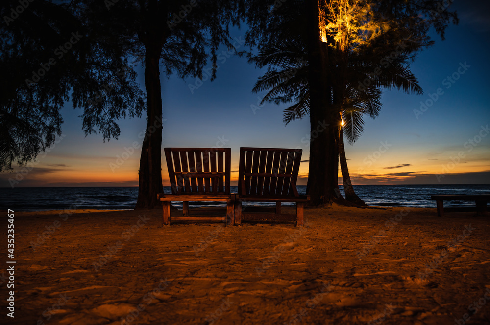 Wooden chair beside the beach with beautiful idyllic seascape sunset view on kohkood island.Koh Kood, also known as Ko Kut, is an island in the Gulf of Thailand