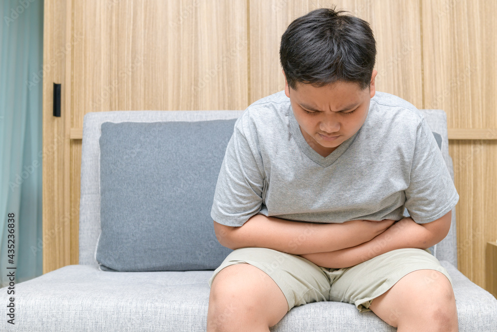 Fat boy feeling stomachache and sitting on the sofa, Diarrhea concept Fat boy feeling stomachache and sitting on the sofa, Diarrhea concept