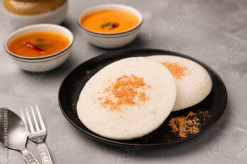 Thatte idli or Plate idly with sambar coconut chutney, chutney podi popular breakfast of Kerala South India Sri Lanka. Healthy steamed rice cakes steaming fermented batter black lentils and rice. photo