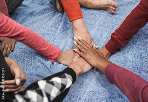 Stacking hands of multiracial women - Multi generational people - Team concept