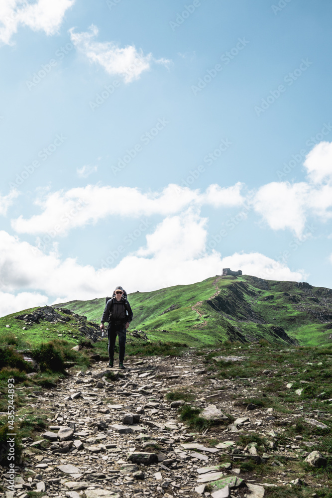Obraz premium young hiker man in mountains. summer trekking path