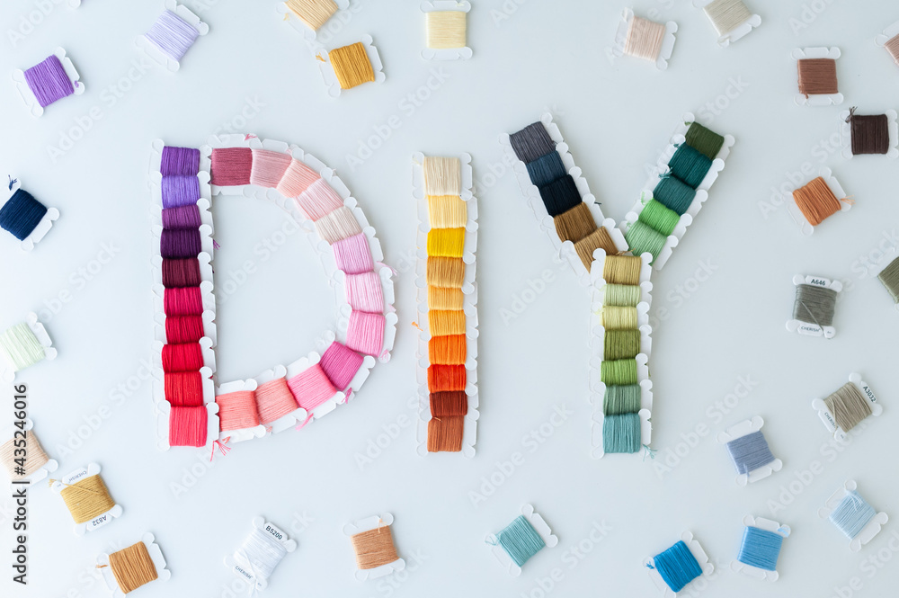 Word DIY world made of colorful bobbins, treads. Do it yourself concept. Sewing, hobby