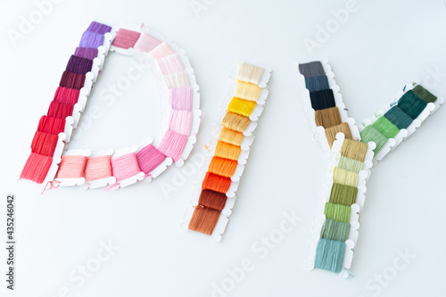 Word DIY world made of colorful bobbins, treads. Do it yourself concept. Sewing, hobby