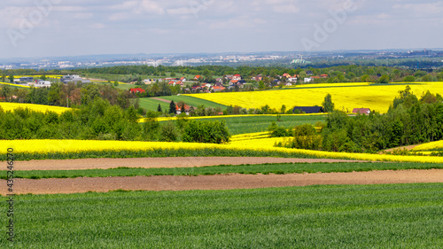 landscape of fields and lakes. in the distance you can see towns and forests 