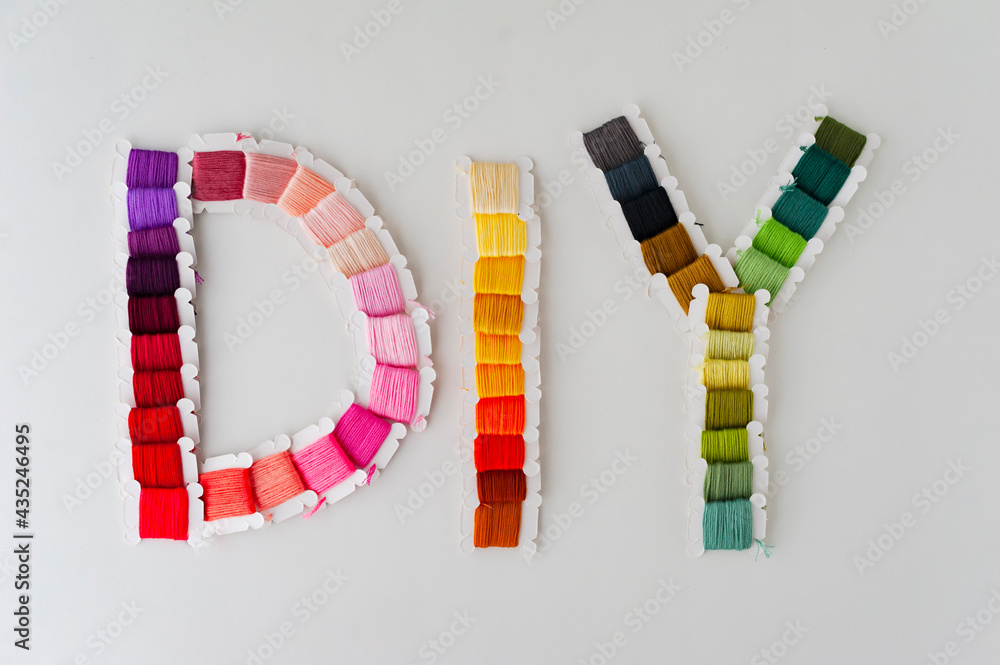 Word DIY world made of colorful bobbins, treads. Do it yourself concept. Sewing, hobby