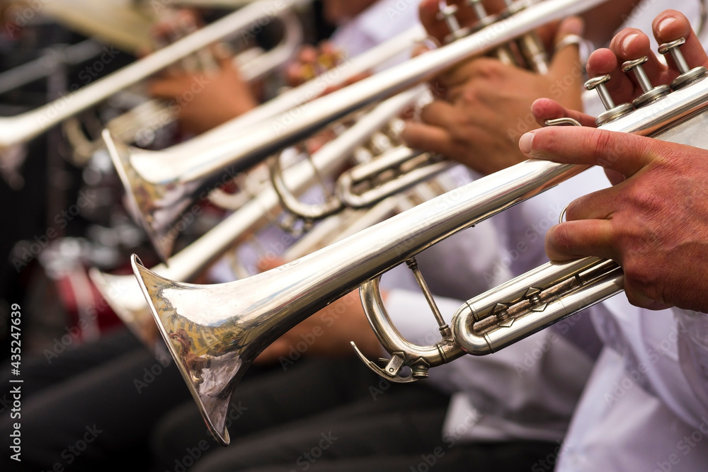 Obraz premium Wind instruments. Hands on musical instruments. Musicians play pipes. Hands of man playing the trumpet in the orchestra