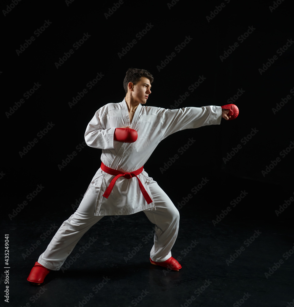 Male karate fighter in white kimono and red gloves Male karate fighter in white kimono and red gloves