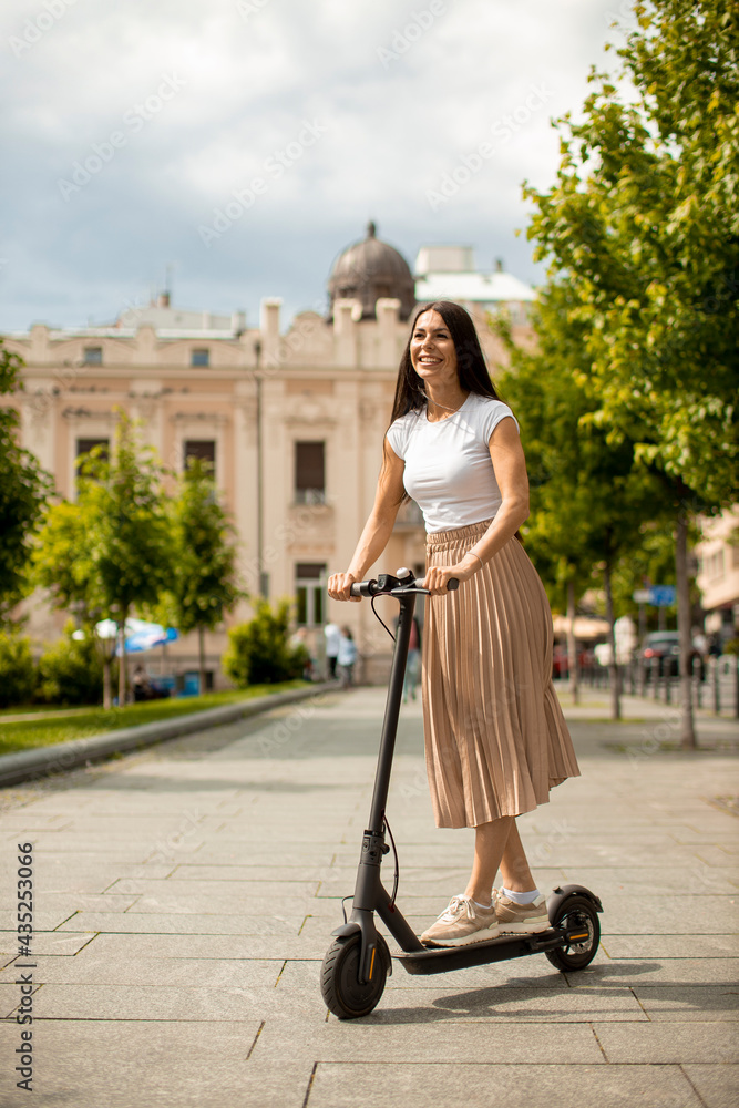 Young woman riding an electric scooter on a street Young woman riding an electric scooter on a street