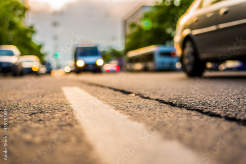 Setting sun in the suburbs, the cars driving on road. View from the level of the dividing line © Georgii Shipin