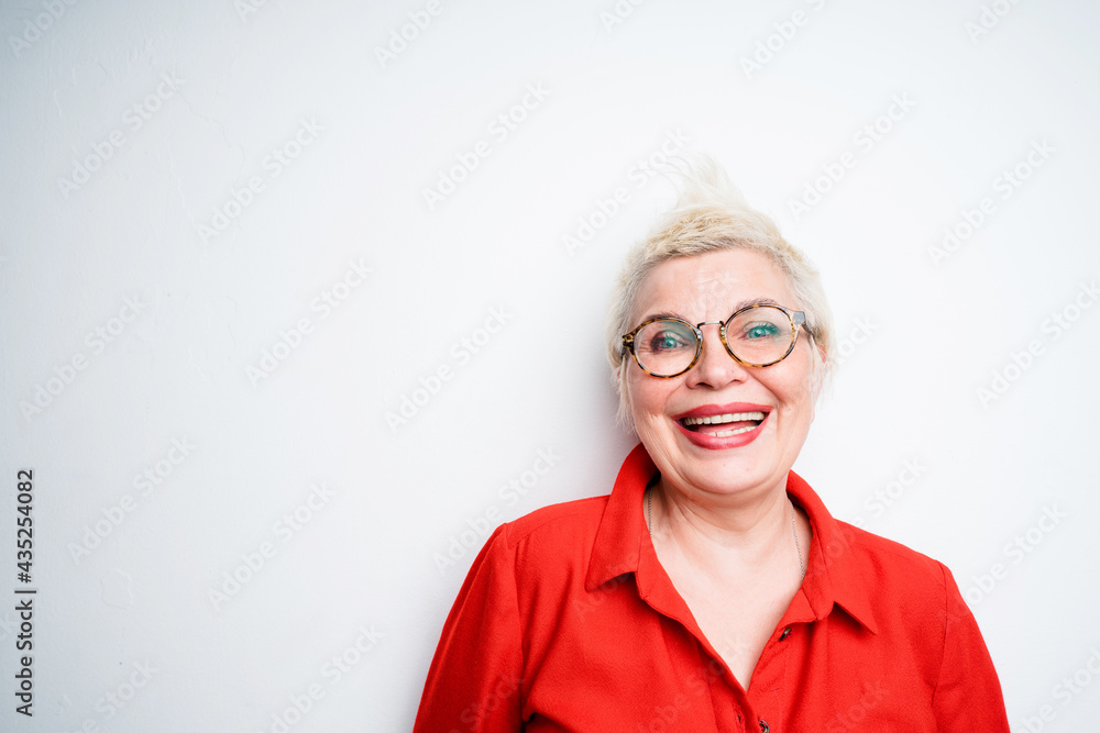 Happy elderly woman wearing short haired eyeglasses smiling broadly looking at camera