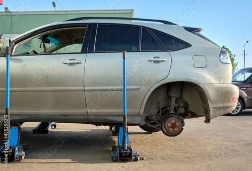 Tyre service: a car standing on hidraulic jacks © Aleksei