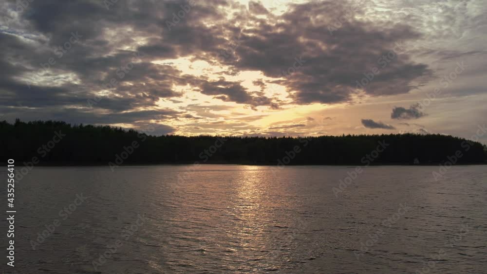 sunset over the lake, camera flight over the water in which the setting sun is reflected and glare on the water, the golden hour, orange clouds in the light of the setting sun over the lake in the for sunset over the lake, camera flight over the water in which the setting sun is reflected and glare on the water, the golden hour, orange clouds in the light of the setting sun over the lake in the for