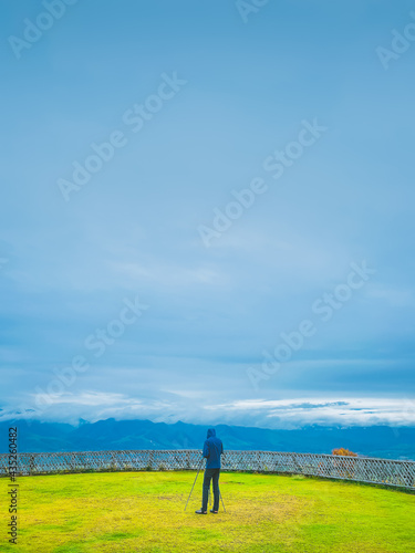 Young man photographer working with tripod on the top of the hill , inspiration , freedom and recreation concept © XOOXO