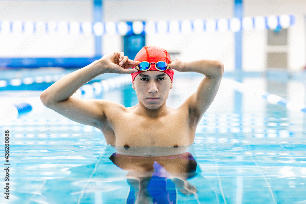 Disabled Swimmer latin boy Training In Pool with hand hypoplasia in disability concept