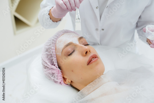 A young girl in a cosmetology office is undergoing facial skin rejuvenation procedures. Cosmetology.