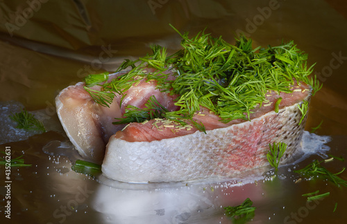 Salmon steak with dill and herbs on metalpaper, closeup, horizontal photo