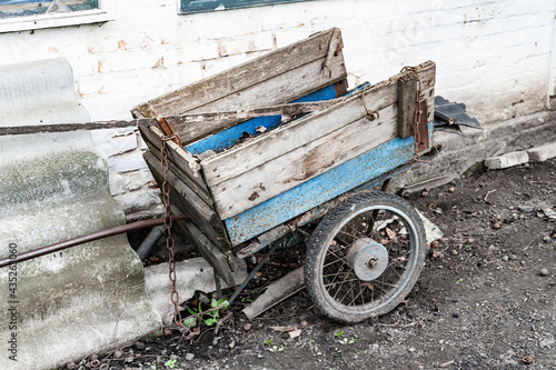 Old wheelbarrow. Old worn wheelbarrow for wood stands in a farm.