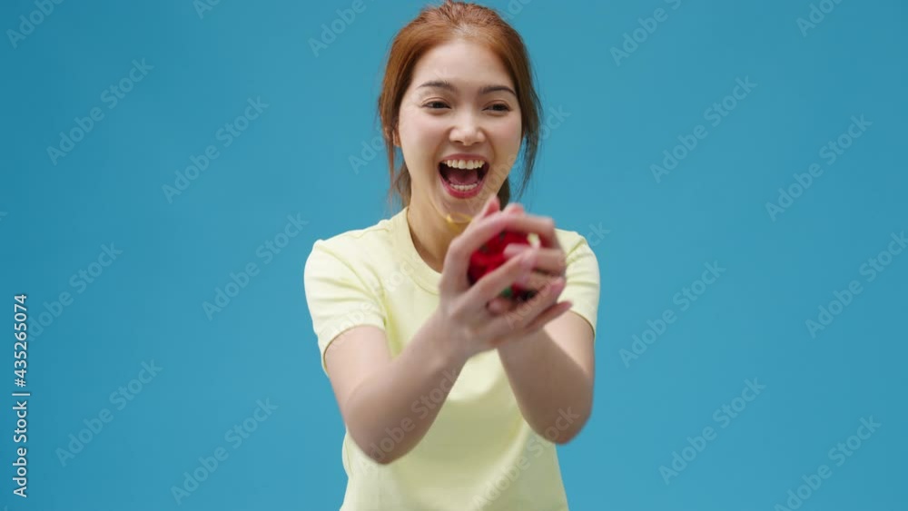 Young Asia girl smile and receiving present box isolated over blue background. Copy space for place a text, message for advertisement. Advertising area, mockup promotional content. Young Asia girl smile and receiving present box isolated over blue background. Copy space for place a text, message for advertisement. Advertising area, mockup promotional content.