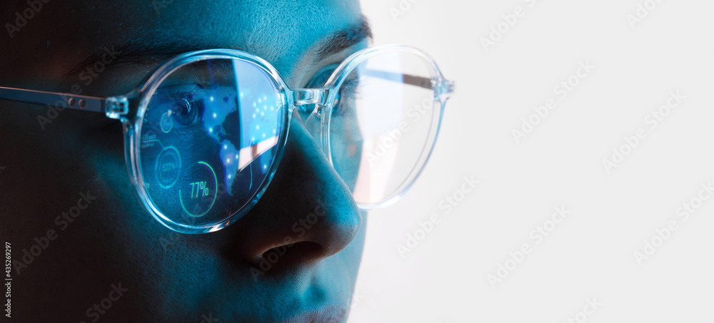 Close up view of blue eye in glasses with futuristic holographic interface to display data. Portrait of beautiful young woman, half of face. Augmented reality, future technology, internet concept. - obrazy, fototapety, plakaty 
