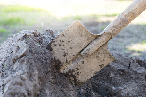 Shovel in the ground, close-up. Preparing the land for planting, garden maintenance