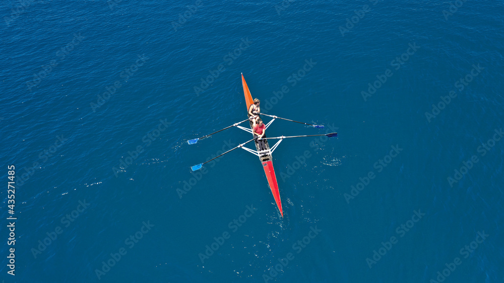 Fototapeta premium Aerial drone top down photo of sport canoe operated by team of young women in emerald calm sea waters