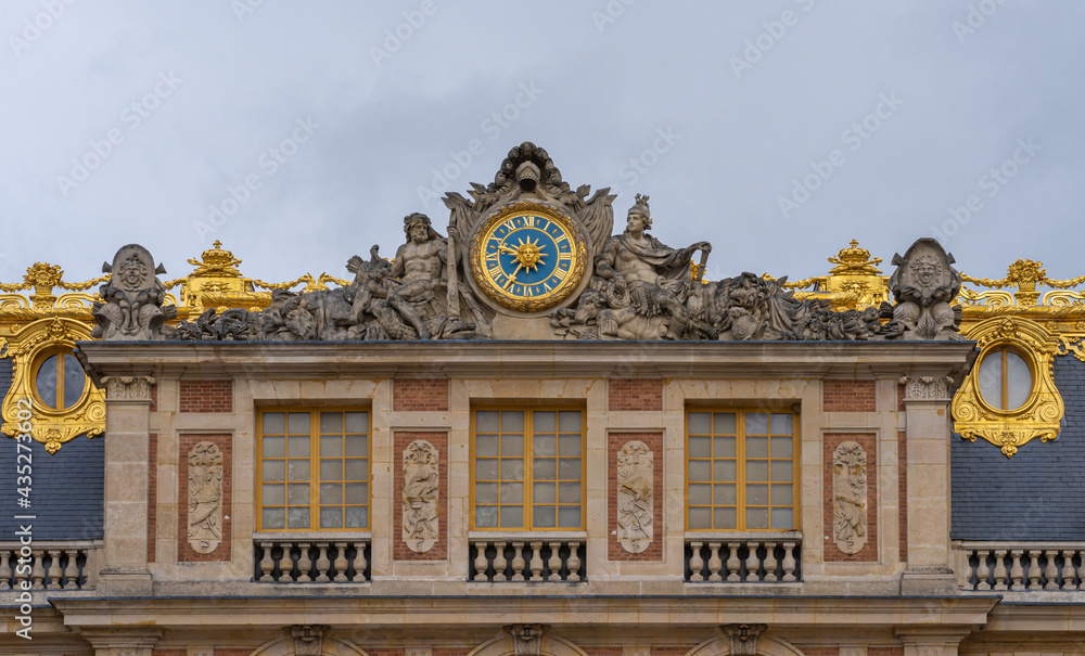 Versailles, France - 19 05 2021: Castle of Versailles. Detail of the clock on top of the facade of the Castle of Versailles from the Marble Court