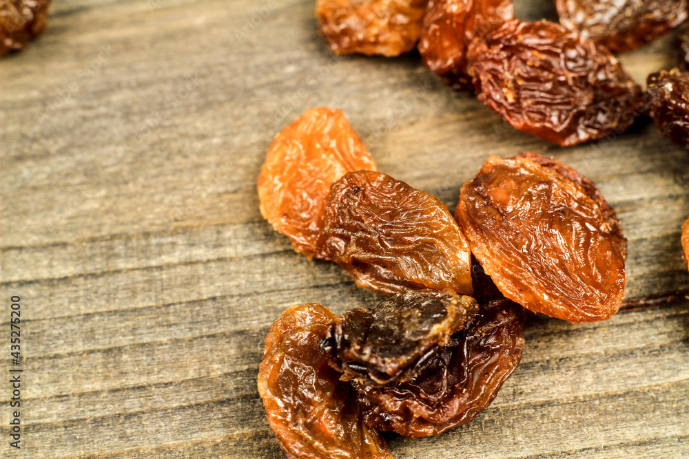 Sultana raisins on gray wooden board Sultana raisins on gray wooden board