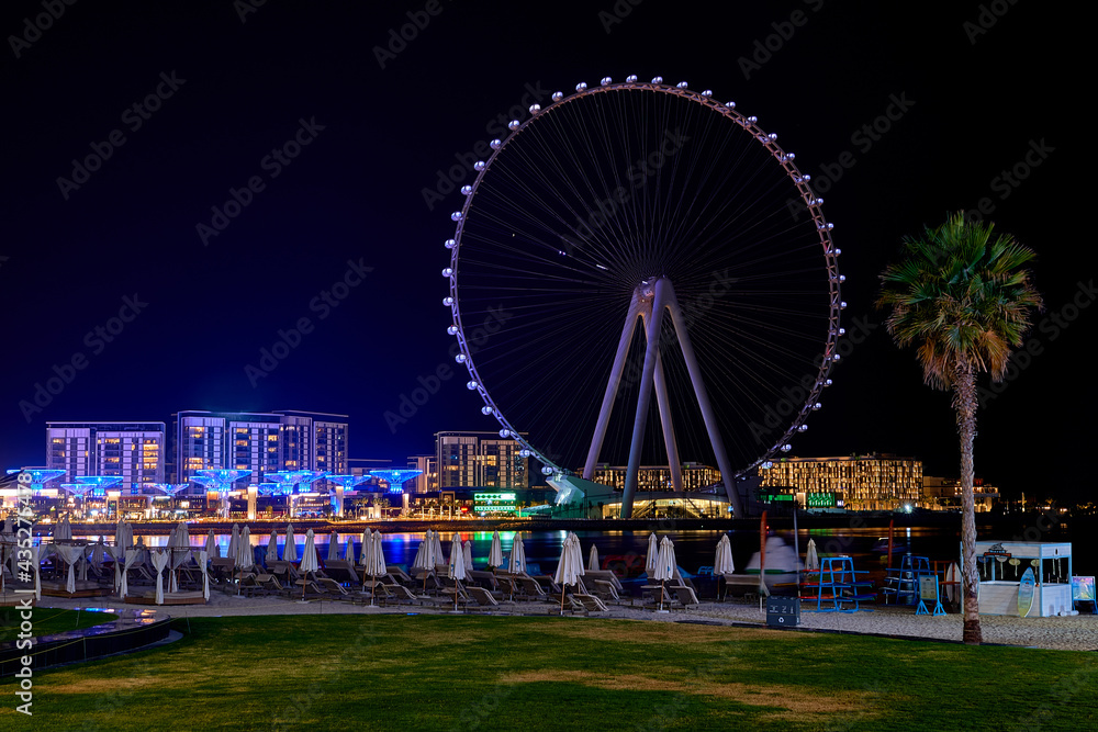 the ferris wheel stands on the banks of the Dubai waterfront