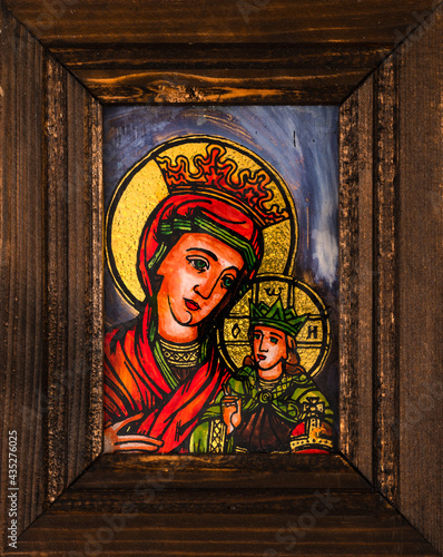 Framed icon painted on reverse glass in the naive orthodox style of Eastern Europe depicting Virgin Mary and baby Jesus.