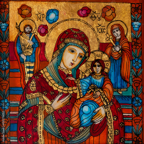 Icon painted on reverse glass in the naive orthodox style of Eastern Europe depicting Virgin Mary and baby Jesus.