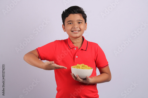 Indian kid or boy eating noodles.